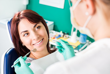 smiling young woman getting general dentistry services performed by dentist 