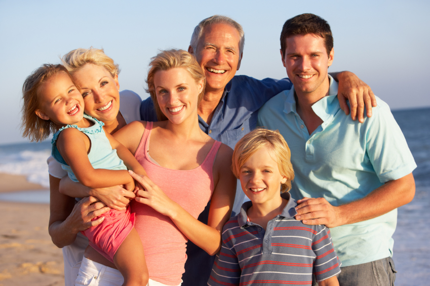 a family portrait at the beach smiling 