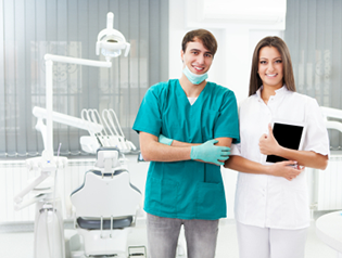 Dental office staff members smiling and standing next to each other